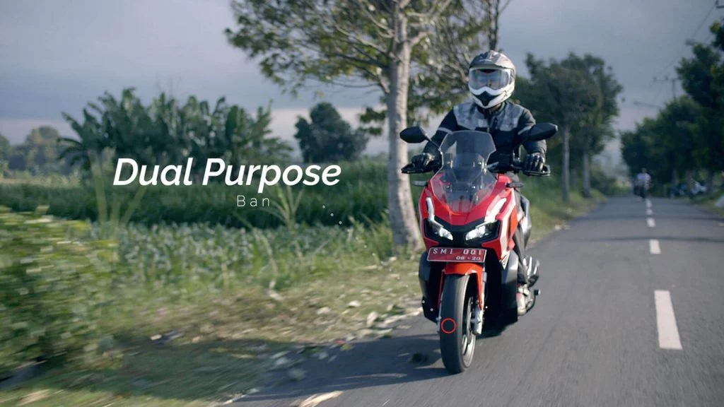 honda adv 150 abs warna merah di jalan.